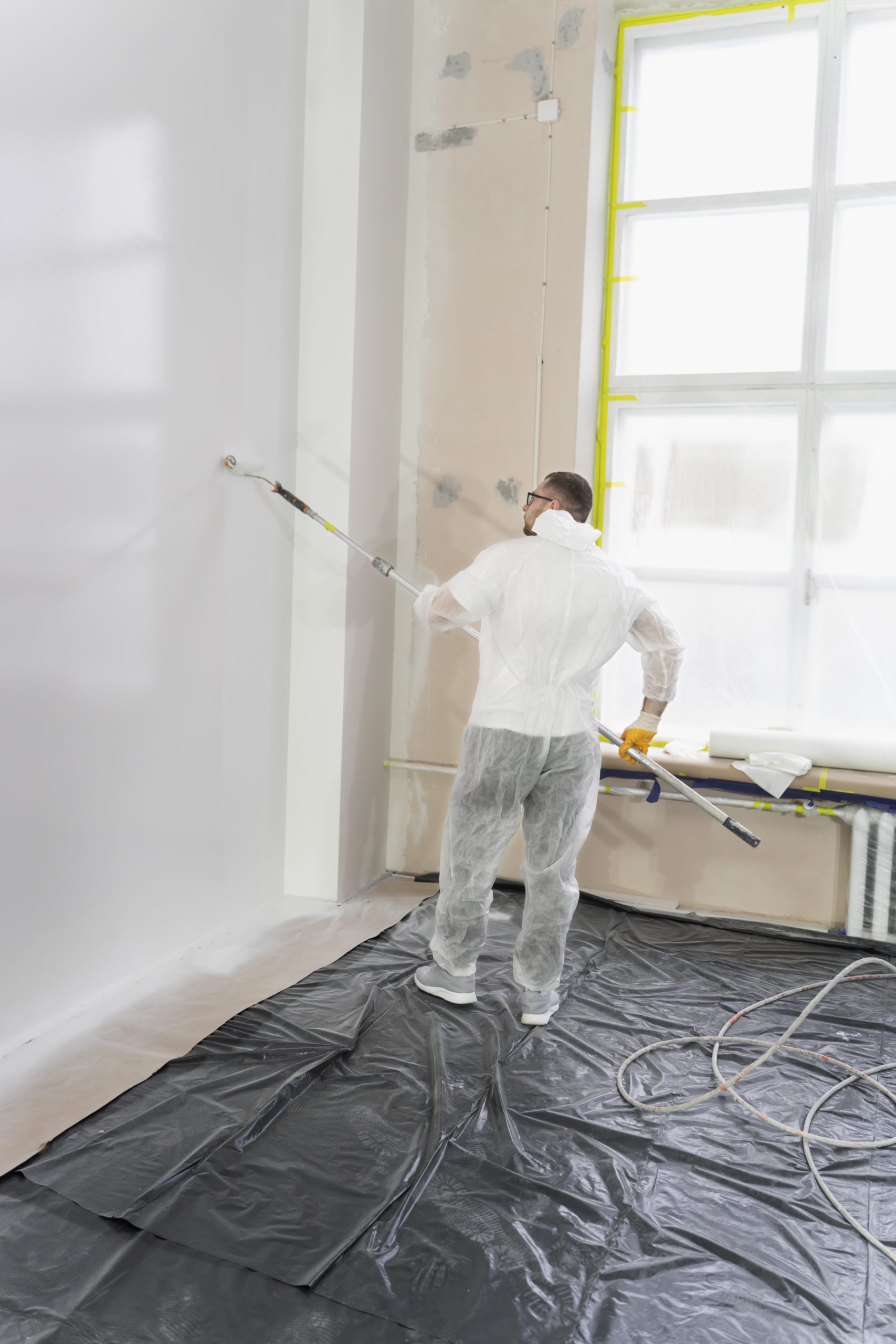young-worker-painting-wall-full-shot